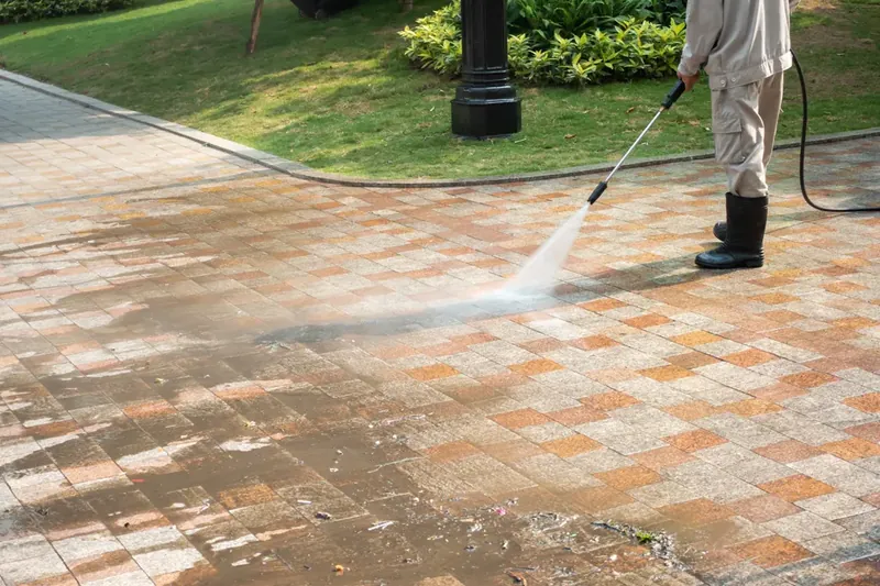 Power washing a brick paver driveway
