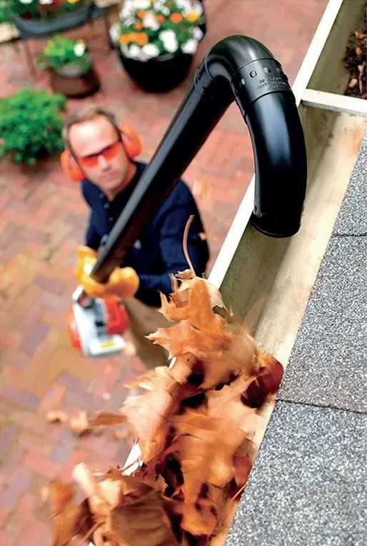 Clearing leaves out of a gutter