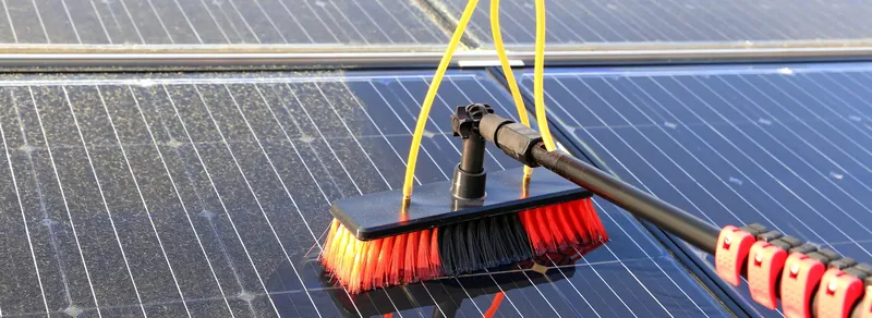 Cleaning solar panels with a soft brush and water-fed pole